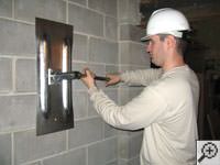 Attempting to straighten a bowed foundation wall by straightening a wall anchor system in a Burlington home.