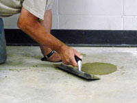 Repairing the cored holes in the concrete slab floor with fresh concrete and cleaning up the Burlington home.