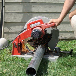 Cutting the support beam for a crawl space jack post outside a Burlington home.