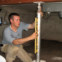 A contractor in Barrie installing a crawl space jack post.