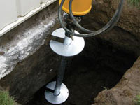 Installing a helical pier system in the earth around a foundation in Hamilton
