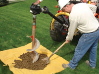 Auguring a hole in the earth for a foundation wall repair system in Burlington
