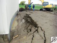 A foundation wall showing severe damage from bowing and buckling in Ajax