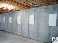 Wall anchor covers installed along a foundation wall that has been straightened in Orangeville.